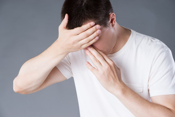 Headache and migraine, man with head pain on gray background