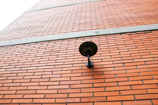 Lamp light on orange brick wall