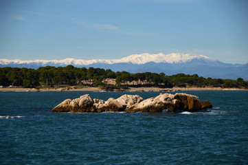 Vista de las rocas de L'Escala con los Pirineos nevados de fondo