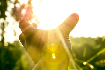 Use hand to touch sun light in the peace morning, freedom lifestyle and tranquility, Pray for wellness, love and faith from holy god, Take meditation in nature with silhouette sky nature light