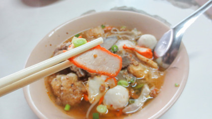 bowl of spicy tom yum noodle soup with pork in Thai style