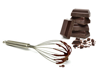 Chocolates and whisk isolated on white background