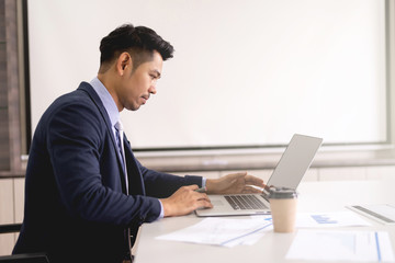 Young businessman concentrate working on laptop with white screen background