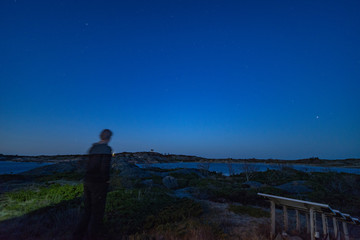 a man and the solar panels under night sky