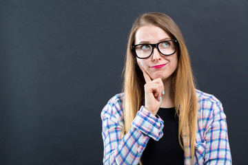 Young woman in a thoughtful pose on a black background