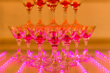 glasses of champagne and cherry in pink light
