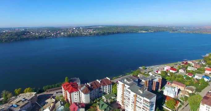 Aerial shooting of city and lake from the quadrocopter. City and lake from the bird's-eye view.
