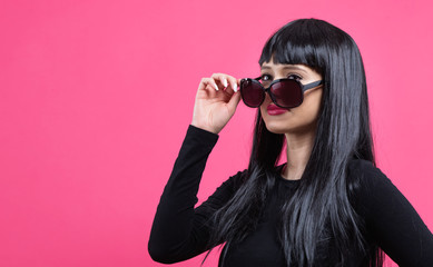 Fashionable woman in sunglasses on a pink background