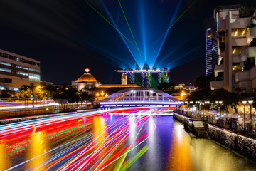 Fototapeta na wymiar Singapore skyscrapers and passenger boat light trails at night
