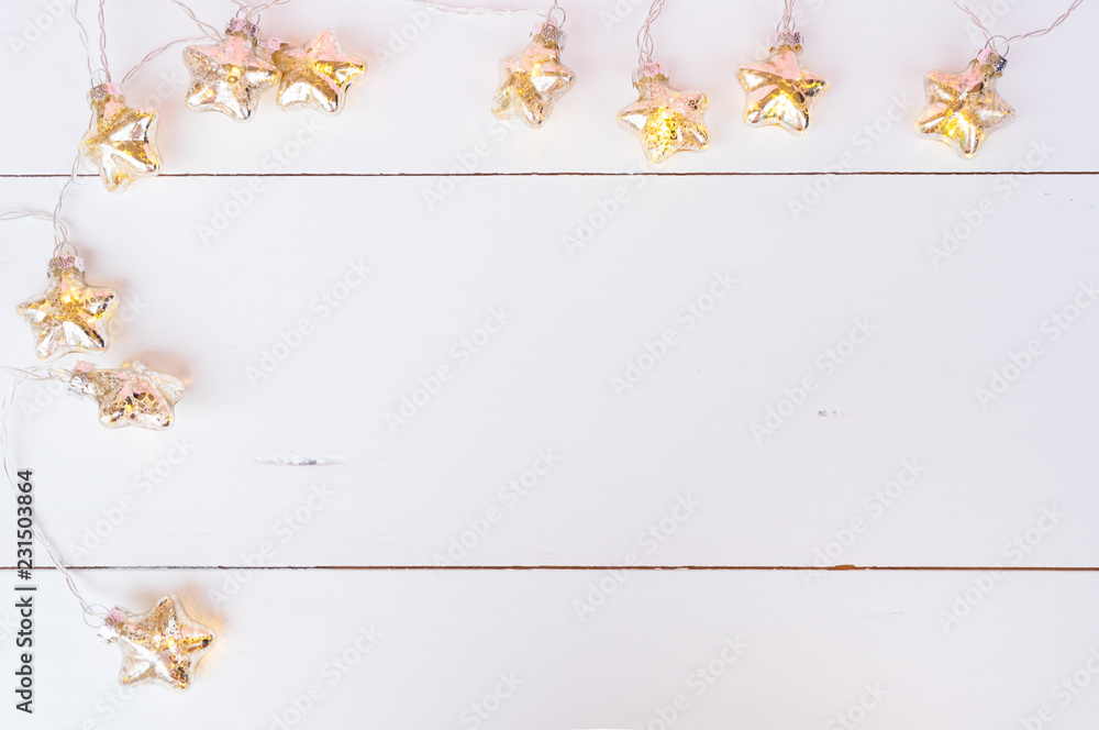 Wall mural Christmas glowing garland on white wooden background