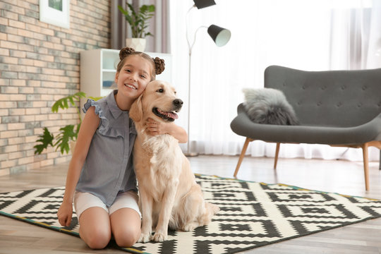 Cute little child with her pet on floor at home