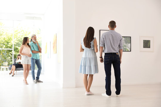 Young couple at exhibition in art gallery