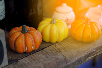 Three pumpkins that adorn the wooden table.