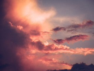 Beautiful romantic sky with pink puffy clouds during sunset.