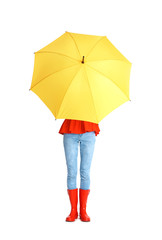 Woman hiding under yellow umbrella on white background