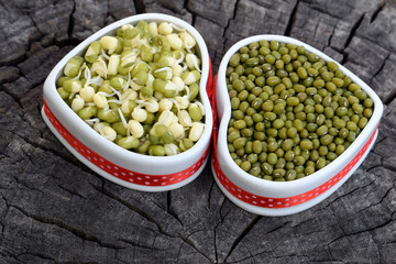 Dry and sprouted mung beans in ceramic bowls of heart shape