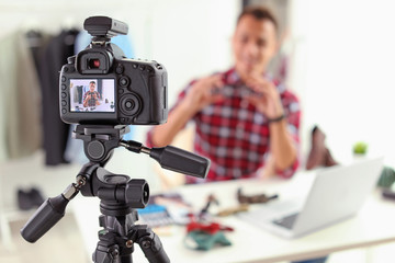 Fashion blogger recording video indoors, focus on camera display. Space for text