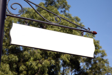 Blank vintage street sign with a large tree in the background.