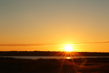 Picturesque view of beautiful sunrise on riverside. Morning sky