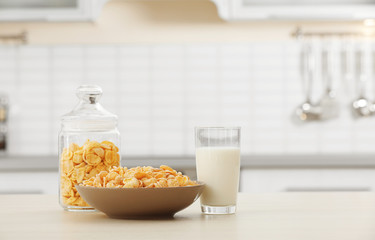 Cornflakes with glass of milk on kitchen table