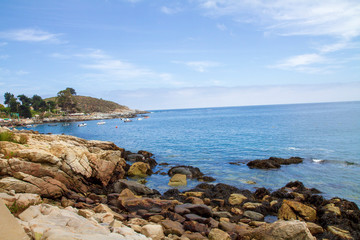 Fototapeta na wymiar Chilean zapallar beach in a sunny afternoon with some rocks foreground