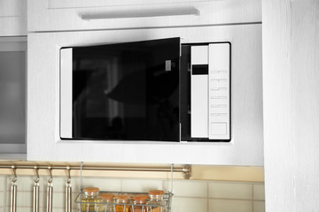Open modern microwave oven built in kitchen furniture