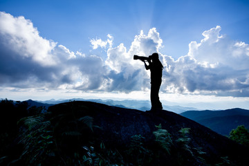 Silhouette of a man who like to travel and photographer, taking pictures of the beautiful moments during the sunset ,sunrise.