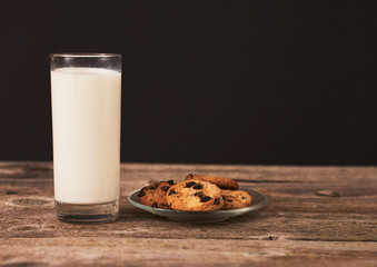 chocolate cookies for Santa and glass of milk on wood board