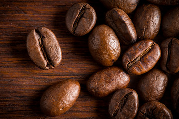fresh roasted coffee beans macro close up on natural dark oak wood background