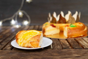 piece of Roscon de Reyes traditional spanish cake for Epiphany festivites on wooden table