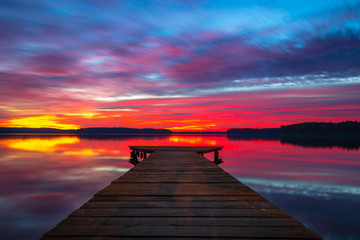 Fototapeta na wymiar Beautiful colourful sunset with a wooden jetty in the Lake