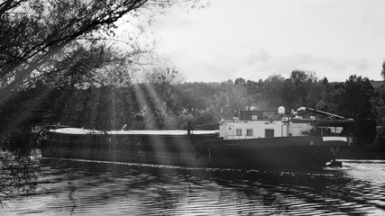 Cargo ship on the river Main in Franconia in backlight, black and white