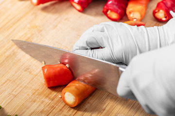 cook cutting hot chili peppers