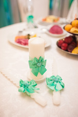 Wedding decoration. Candles with turquoise ribbons on the table