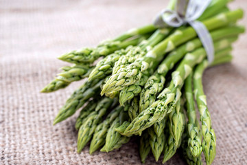 Row green Asparagus as close-up on a gunnysack with copy space left