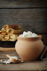 Cottage cheese in  clay pot. and pancakes. Copy space for text..