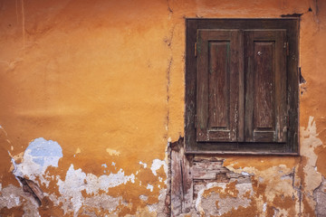 old derelict house with shutters and fallen plaster