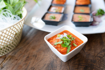 Chili sauce in white bowl on table