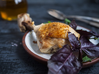 Dinner of chicken leg, fresh salad. The sauce in a glass saucepan.