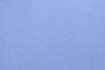 Texture of old blue paper background, closeup. Structure of dense dark denim cardboard.