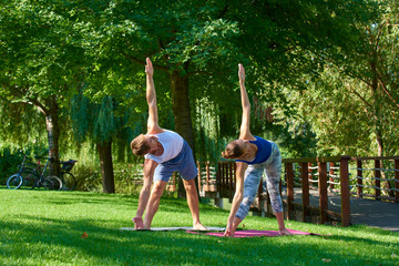 Obraz premium Young couple doing exercises outside in the park