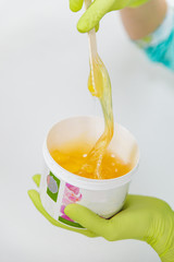 woman interfere warm up sugar for sugaring