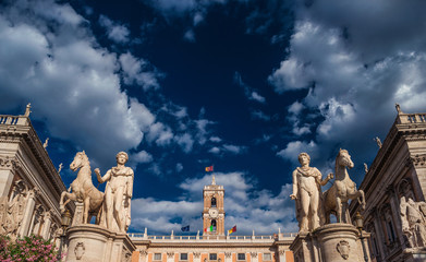 Capitoline Hill with ancient roman statues and renaissance clocktower with clouds, in the very...