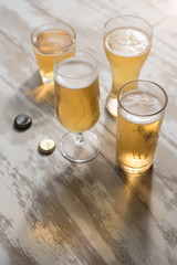 Glasses of beer with reflection on table wooden