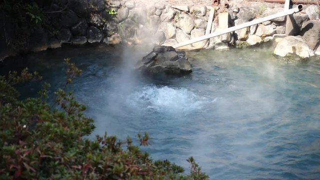 hot thermal spring framed by granite boulders. Japan, Beppu.