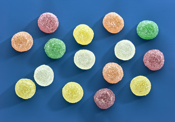 Colored jelly beans sorted on colored background
