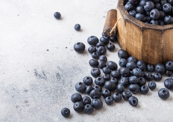 Fresh raw organic blueberries in vintage wooden box on stone kitchen background. Food concept