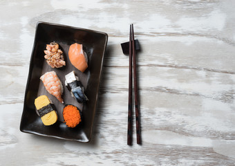 Sushi set with chopsticks on old wooden background,top view