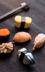 Sushi set with chopsticks on old wooden background