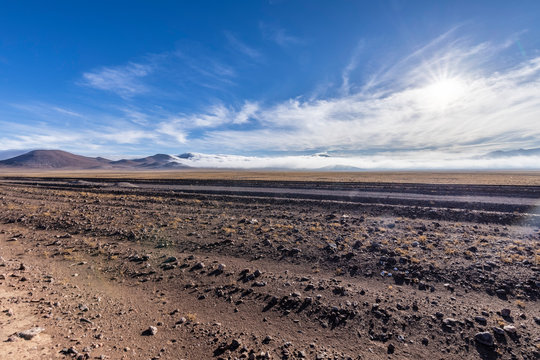 A panoramic view over the Atacama Desert valleys with the humidity coming from the sea and called "Camanchaca" on the far distance at the horizon line. An amazing desert landscape.
